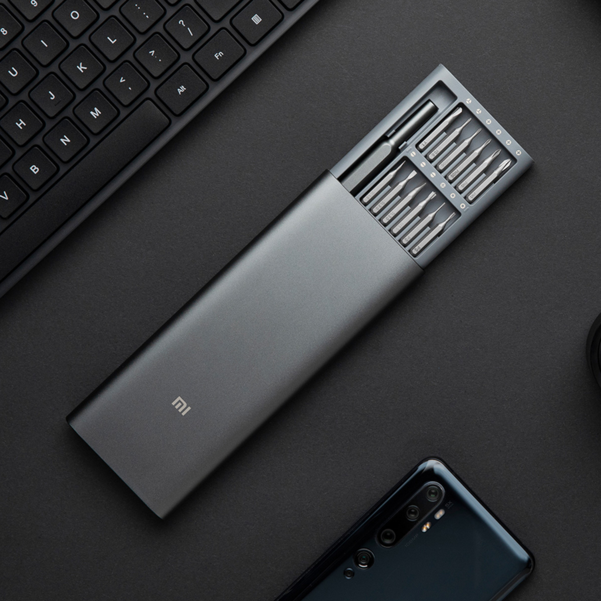 Trusa Xiaomi Mi Precision pe un birou, lângă o tastatură și un telefon